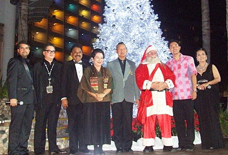 (l-r) Tony Malhotra, Jorge Carlos Smith, Peter Malhotra, Khunying Busyarat and Gen. Kanit Permsub, Santa Claus, Mayor Itthiphol Kunplome and Rungratree Thongsai gather for a photo in front of the lit up Christmas tree.