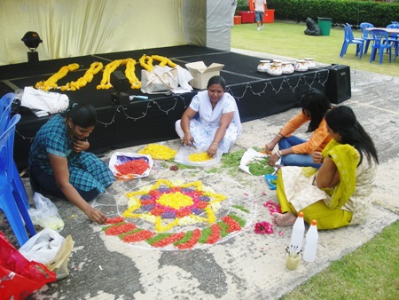 Parents make rangoli.