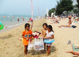 Three young beachcombers help to keep the place clean.