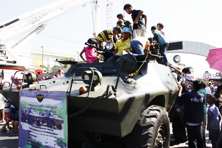 Children at Pattaya City Hall are given the chance to climb aboard a military vehicle.