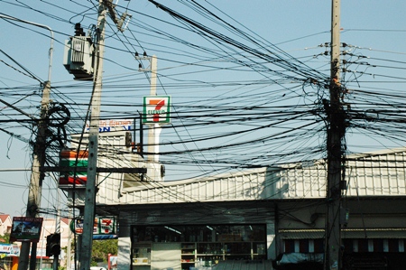 The tangled mess of electric and phones cables of different shapes and sizes hangs precariously above the road and sidewalks at the soi 17 intersection on Third Road.