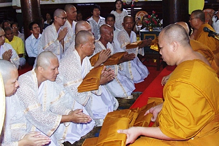 Novices receive their first robes from revered monks at Yai Intharam Temple in Chonburi.