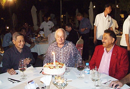 Alwin Zecha (left) and Peter Malhotra (right) urge Ferenc to make a wish and blow out the candle.