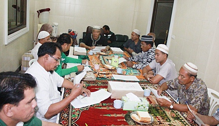 A planning committee, led by Faruk Wongborisuthi (back, center) sorts out plans for a fund raising event.