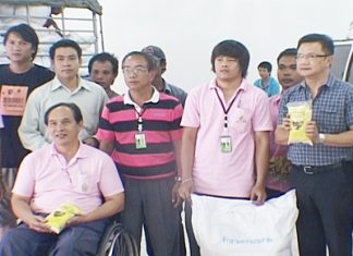 Deputy Mayor Wutisak Rermkitkarn, right, helps volunteers distribute rice to 19 orphanages, shelters and disabled centers in the Pattaya area.