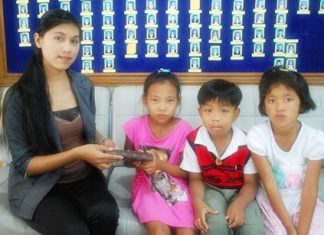 Supanida Chairat, 8, Korakot Arun, 6, and Chonthicha Khempet, 7, return the lost purse to Tasanee Pha-Indee.