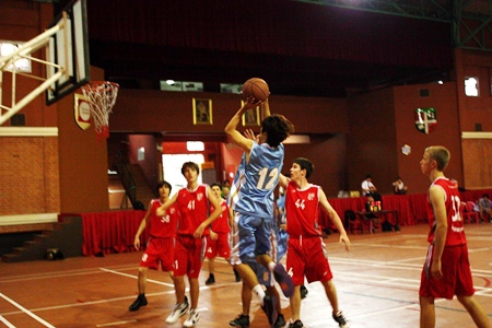 The GIS Storm Varsity team, blue shirts, in action at the ESAC Varsity Boys Basketball Tournament held at Regents School, Saturday, April 2.