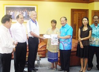 William Macey (center left), representing the Pattaya Sports Club, makes a donation to Mayor Mai Chaiyanit, Nongprue deputy mayors and family to assist families in need.