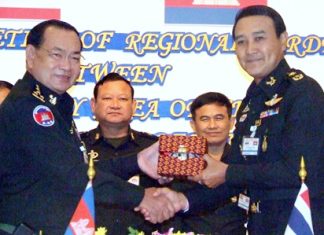 Royal Thai Army Col. Udomek Seetabut and Cambodian 5th Sector commander, Lt. Gen. Bun Seng, jointly sign a memorandum between Thailand and Cambodia.