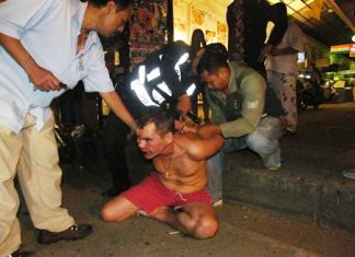 Police and motorcycle taxi drivers wrestle the crazed Russian and put him in handcuffs.