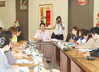 Mayor Itthiphol Kunplome (seated, center) chairs a meeting on AIDS prevention.