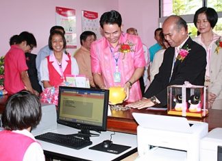 Mayor Itthiphol Kunplome breaks out his piggy bank to show students at Pattaya School No. 3 how to open a savings account.