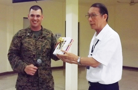 Chaplain Barrett Craig (left), Combat Logistics Battalion 31 accepts souvenir books from Father Veera Phangrak, director of the Pattaya Orphanage. 