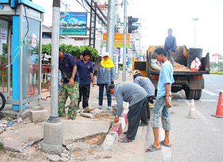 Workers repair damage caused by an accident at the Soi Siam Country Club intersection with Sukhumvit Road.