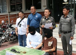Pol. Col. Somnuk Changate (2nd right) brings out the 2 underage boys, part of a gang that robbed a policeman’s condo.