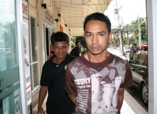 Police bring in Rangsiman Saengworanut for his alleged involvement in an ATM card theft.