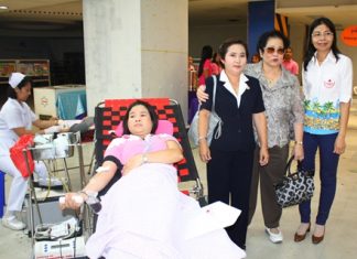 Nuanjan Saeng-Uthai, Banglamung Red Cross president, Mrs. Santana Mekavarakul, president of Mike Group, and Imjai Buncharoenkij, Banglamung Red Cross secretary, encourages a patient donating blood at Mike Shopping Mall.