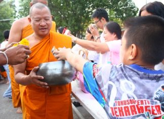 Abbot Pisan Jariyaphiwat leads more than 50 monks to accept alms from large groups of worshippers at Chaimongkol Temple in South Pattaya.