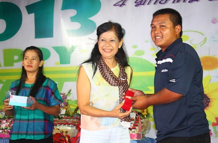 Education Department director Jintana Maensurin (left) presents gold to a lucky employee during the New Year’s party at Pattaya Youth stadium.