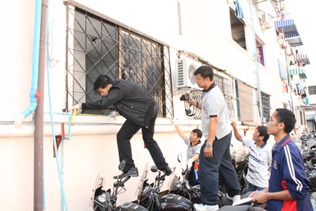 Investigators inspect the scene of a shotgun blast into Pattaya’s new police chief’s residence. 