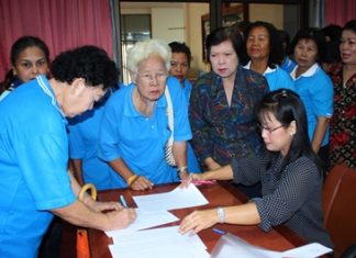 Members of Pattaya’s Elderly Club sign up for a city-organized meditation and merit-making trip to Issan.