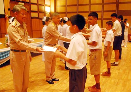 Queen Sirikit Naval Medical Center Deputy Director Vice Adm. Chumpol Thienchai hands out scholarships to children of government employees and navy personnel.