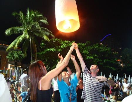 Tourists launch a khomloy into the air for good luck on Pattaya Beach.