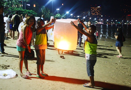 A family prepares to set off a khomloy on Pattaya Beach.