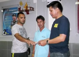 (L to R) Ramin Rajaeetabar receives his money and wallet back from taxi driver Wichian Phonkhong, overseen by Pattaya Police Superintendent Col. Supachai Puikaewkam.