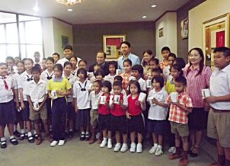 Mayor Itthiphol Kunplome (back, center) and city officials take a group photo with students who received mobile phones.