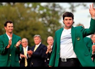 Bubba Watson waves after receiving the jacket from last year’s winner, Adam Scott.