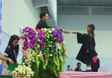 Mayor Itthiphol Kunplome presents a graduation certificate to one of over 2,000 students on March 18 at Pattaya’s at Indoor Stadium.