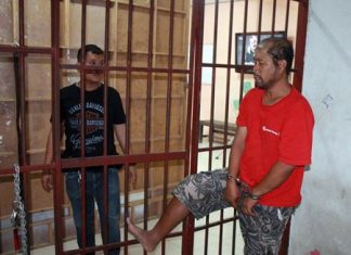 Somyos Anumat (right) shows police how he kicked open the cell door and nearly escaped.