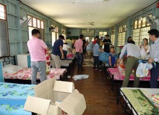 After donating bedding and sporting goods to the Banglamung Home for Boys, members of the South Korean Thai Aridang Association help change bed sheets and clean the fans in the dormitory.