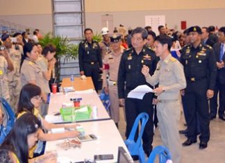 Col. Sirichai Distakul (center right), armed forces chief of joint staff and chairman of the Sub-Committee on Transnational Labor and Human Trafficking, inspects the registration process for foreign workers at Huay Yai’s one-stop center in the Eastern National Sports Training Center.