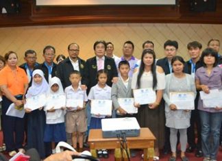 Deputy Mayor Ronakit Ekasingh awards eight scholarships of 500 baht each to students with grade-point averages above 3.5.
