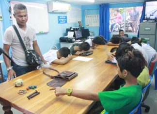 One of eighteen teenagers taken into custody for brawling in Sattahip points to weapons intended for use in the skirmish.