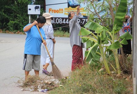 Krung Thai Village residents clean along the road in their community to pay homage to Her Majesty Queen Sirikit.