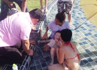 Rescue workers give the girl oxygen while chipping away the concrete to expose the pipe.