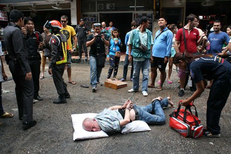 Denis Wieslaw Leszek remains handcuffed on the ground after going into a manic rage on Soi 6.