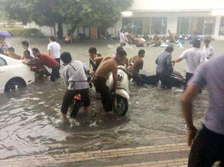 Residents in the Boontaworn area on Sukhumvit struggle to get their cars and motorbikes out of the floods.