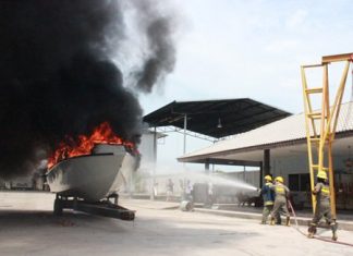 Firefighters work to extinguish the suspicious fire aboard this multi-million baht boat.