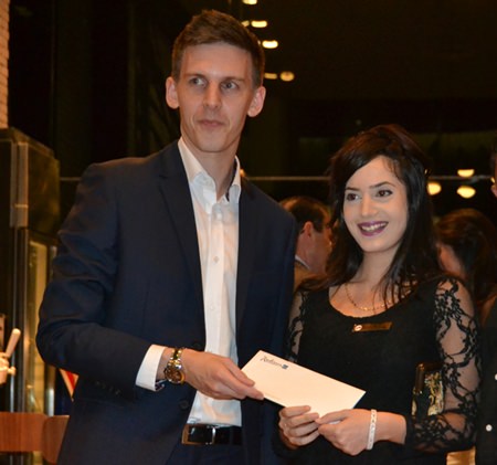 Adam Sutcliffe, sales director for Thailand-proerty.com hands over a hotel voucher to the lucky winner.