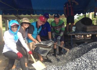 Praichit Jetpai (left), president of the YWCA Bangkok-Pattaya, and volunteers take part in mixing the concrete for the building.