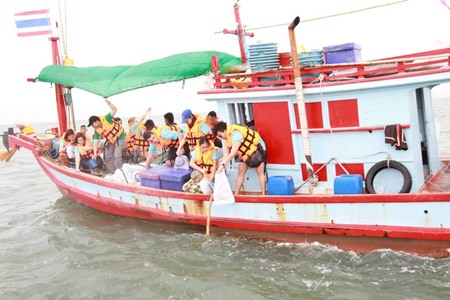 Employees from local hotels set overboard artificial plants made from rope to help restore the marine ecosystem off the shores of Naklua.