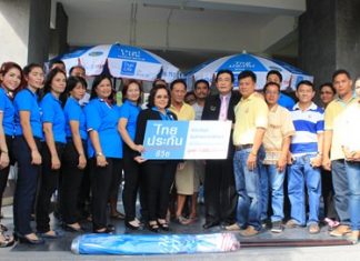 Samran Topao, sales manager for Thai Life Insurance Company, and his management team presents 3,000 umbrellas worth 3 million baht to Deputy Mayor Ronakit Ekasingh to distribute to Jomtien Beach vendors.