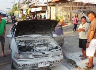 Singhnart Wattanasri (front, right) looks over his burnt out car as others try to console him.