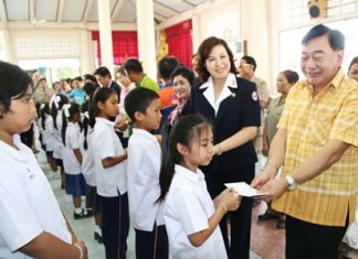 Permanent Secretary Phawat Lertmukda (right) hands out scholarships to Sattahip students as part of Chonburi Provincial Administrative Organization’s efforts to reach out to rural residents.