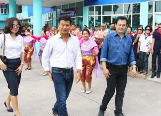 Sattahip’s new district chief, Parinya Photsat (center), receives a warm welcome from residents and public officials as he arrives at the district office.