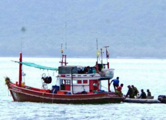 Royal Thai Navy officials board a local fishing boat to check for human trafficking.